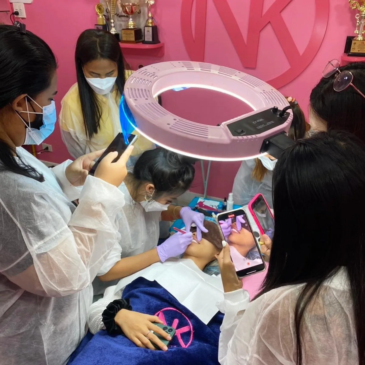Students filming a lip demonstration under the ring light