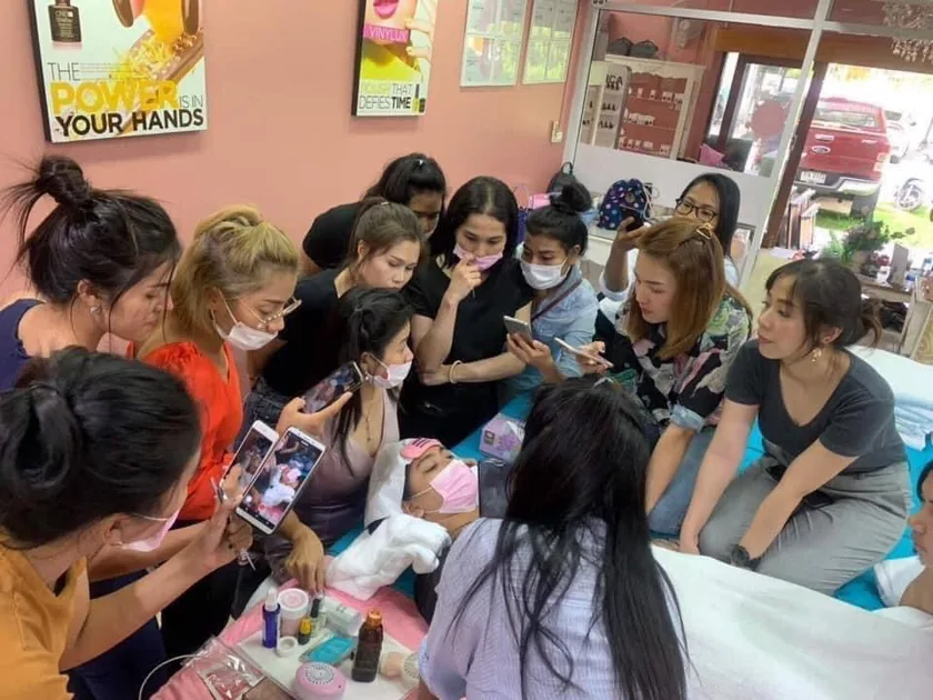 A large group of students watching a lash demonstration on a model