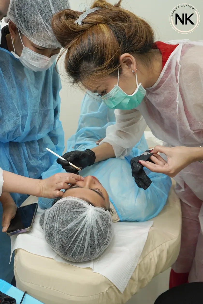 The group gathered around a live model while a technique is demonstrated