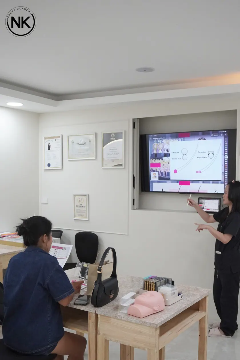 A theory session at NK Beauty Academy, the instructor working through the material with the group