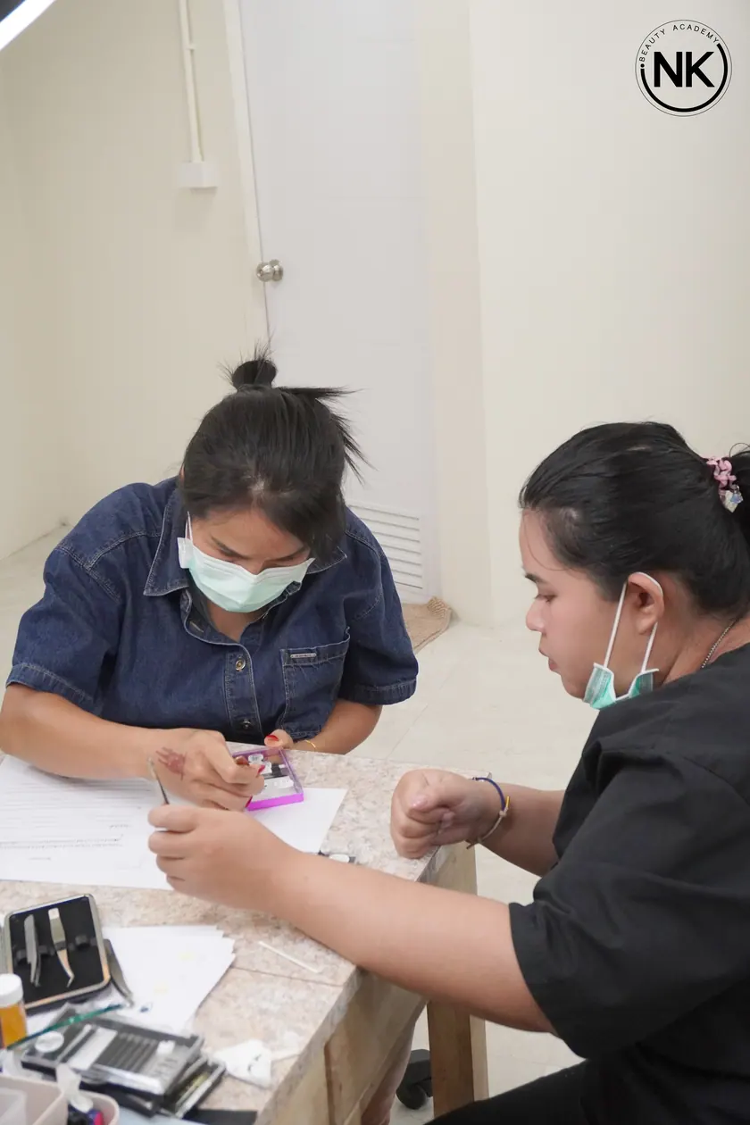A student practising lash work at the training bench before working on a model