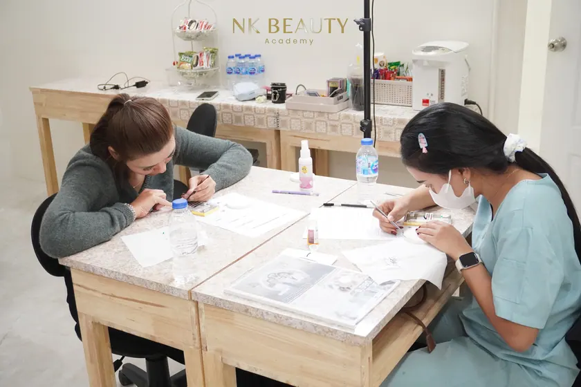 A student practising lash work at the training bench before working on a model