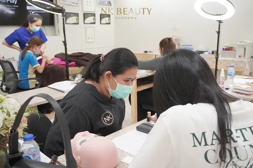 A student practising lash work at the training bench before working on a model