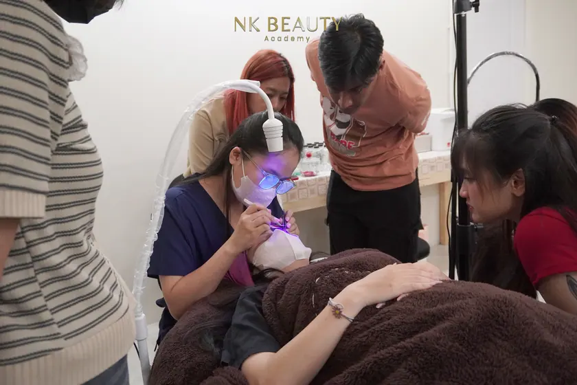 The group gathered around a live model while a technique is demonstrated