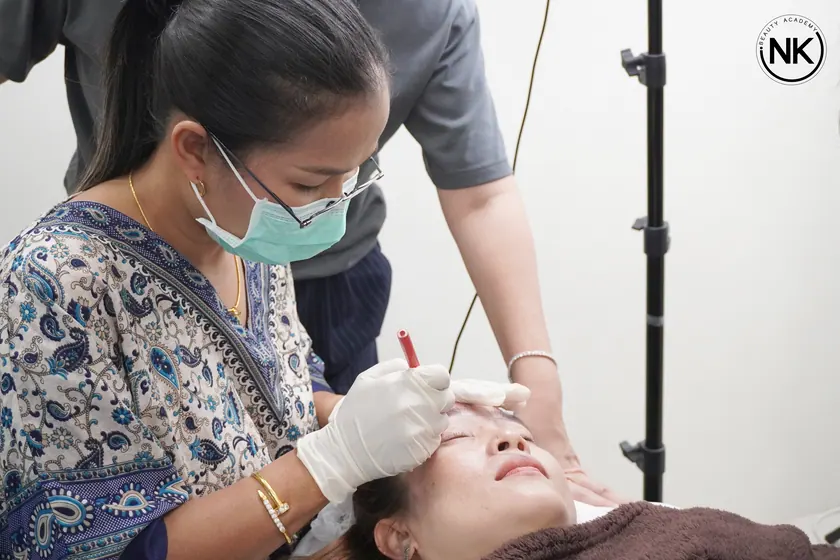 An instructor supervising a student working on a live model