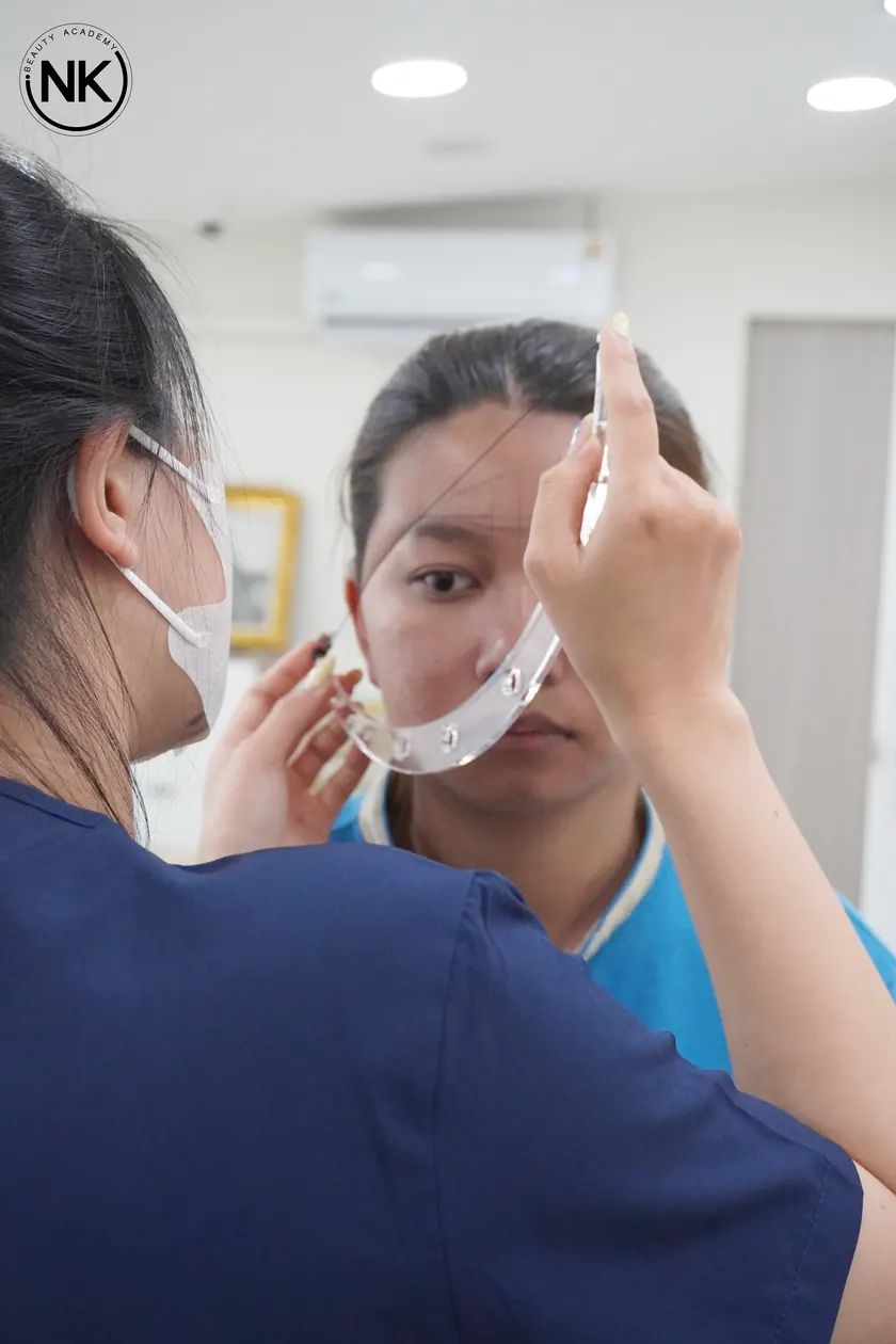 A student working on a live model during the hands-on part of the course