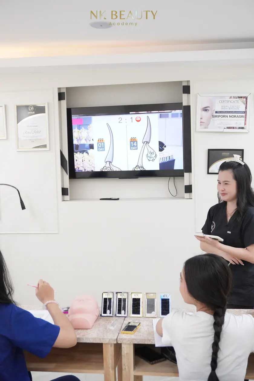 A theory session at NK Beauty Academy, the instructor working through the material with the group