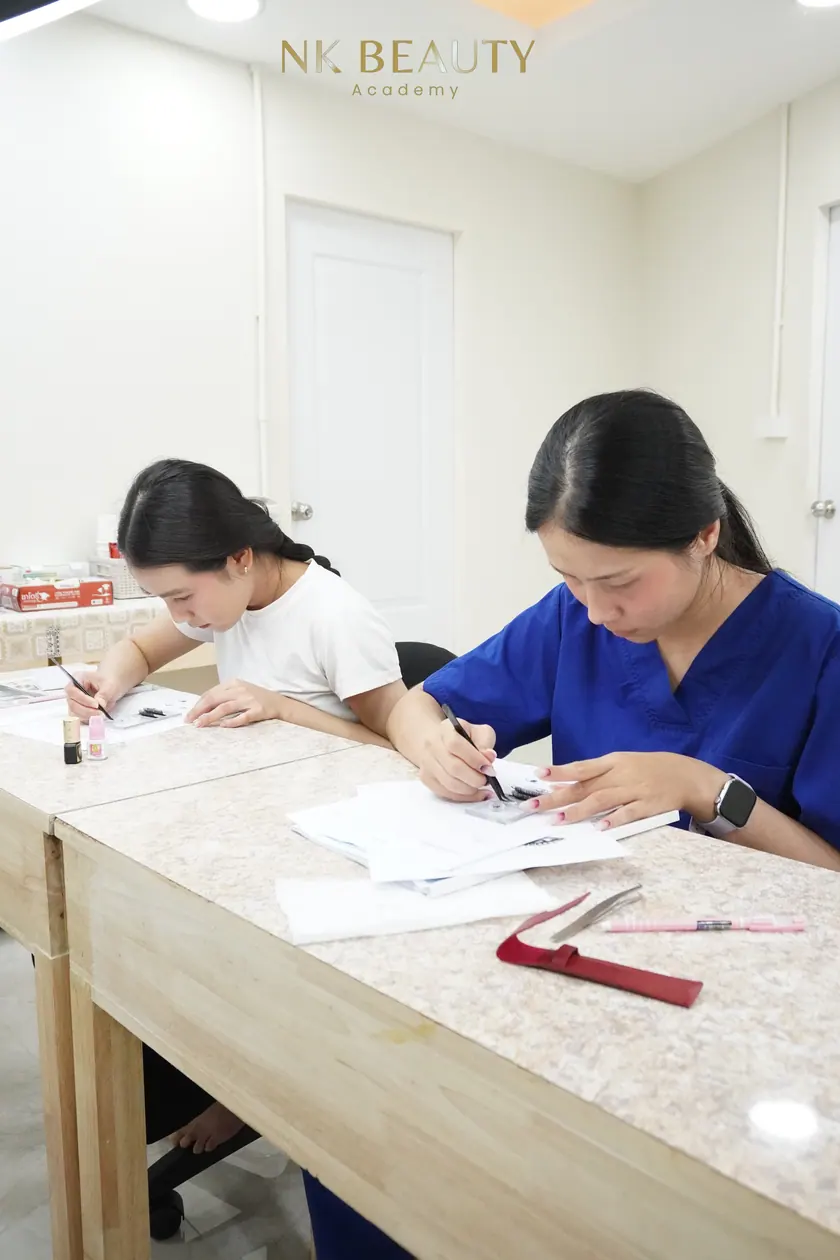 A student practising lash work at the training bench before working on a model