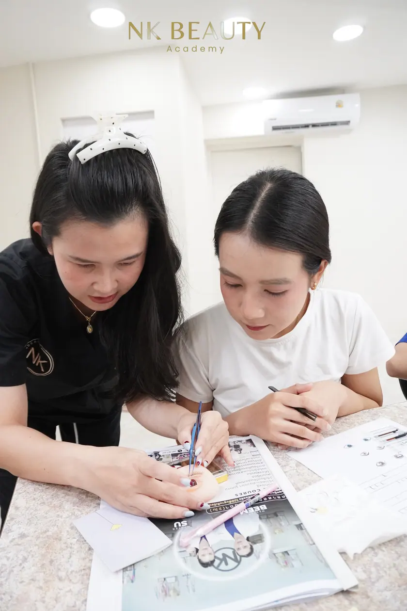 A student practising with tweezers and a lash tray during the course