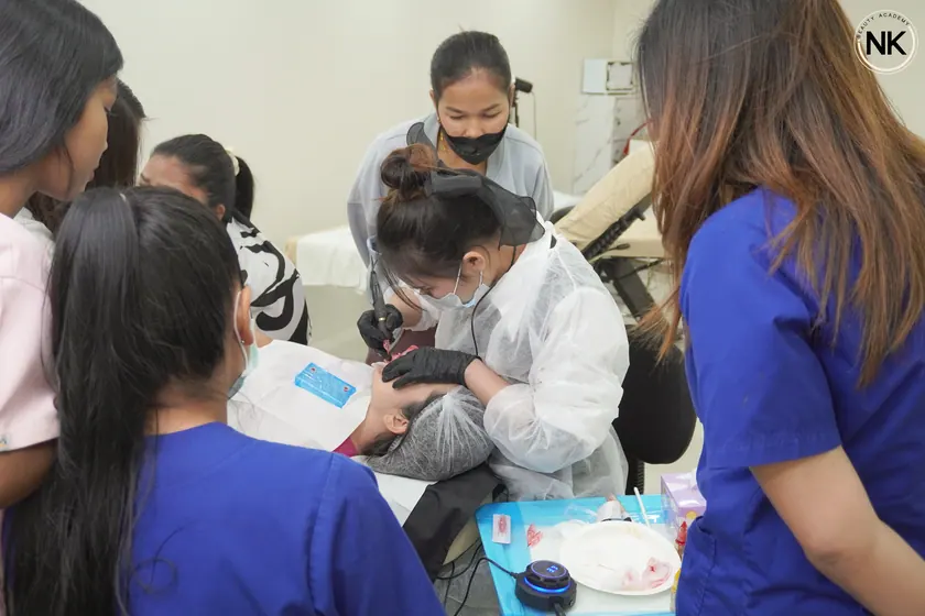 A student practising lash work at the training bench before working on a model