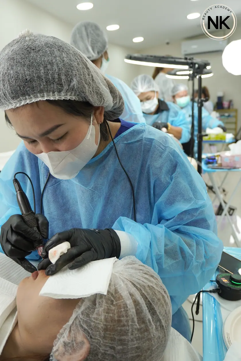 An instructor supervising a student working on a live model
