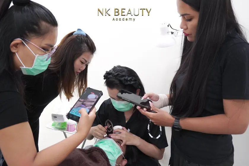 The group gathered around a live model while a technique is demonstrated