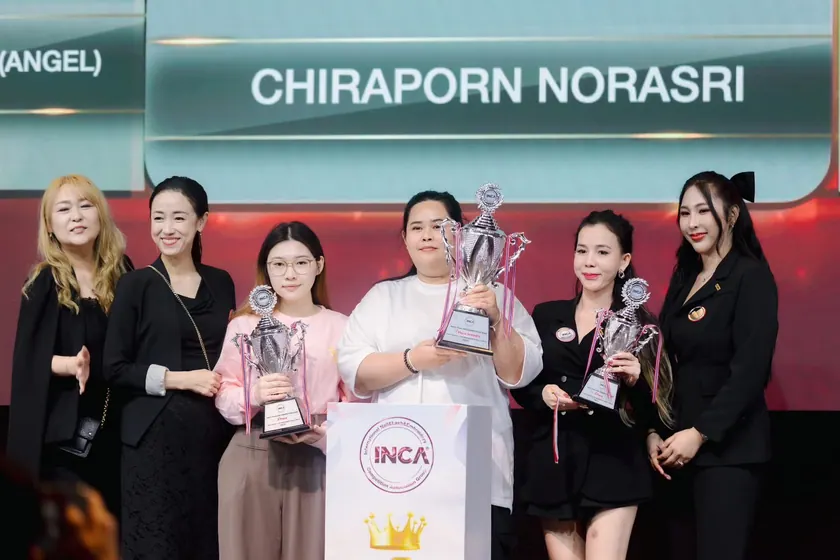 Trophy presentation on the INCA competition stage, the winner name shown on the screen behind