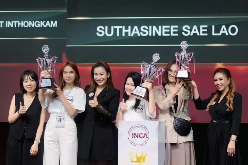 An award being presented at the INCA competition, the recipient name on the screen behind