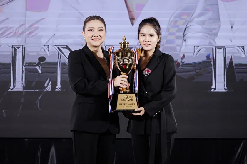 An artist raising a trophy on stage at an industry competition