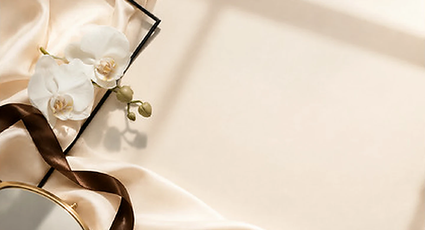 Brand image: orchids and a hand mirror on cream silk
