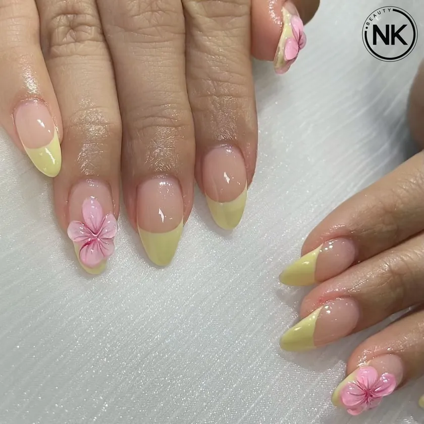 Nail work at NK Beauty: Nude nails with yellow tips and a 3D flower